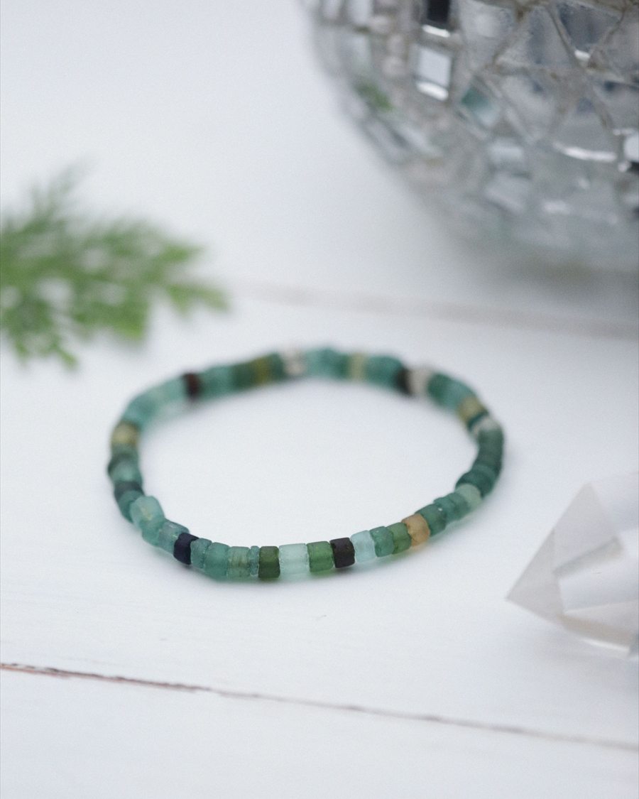 A pale green square-bead bracelet on a white surface