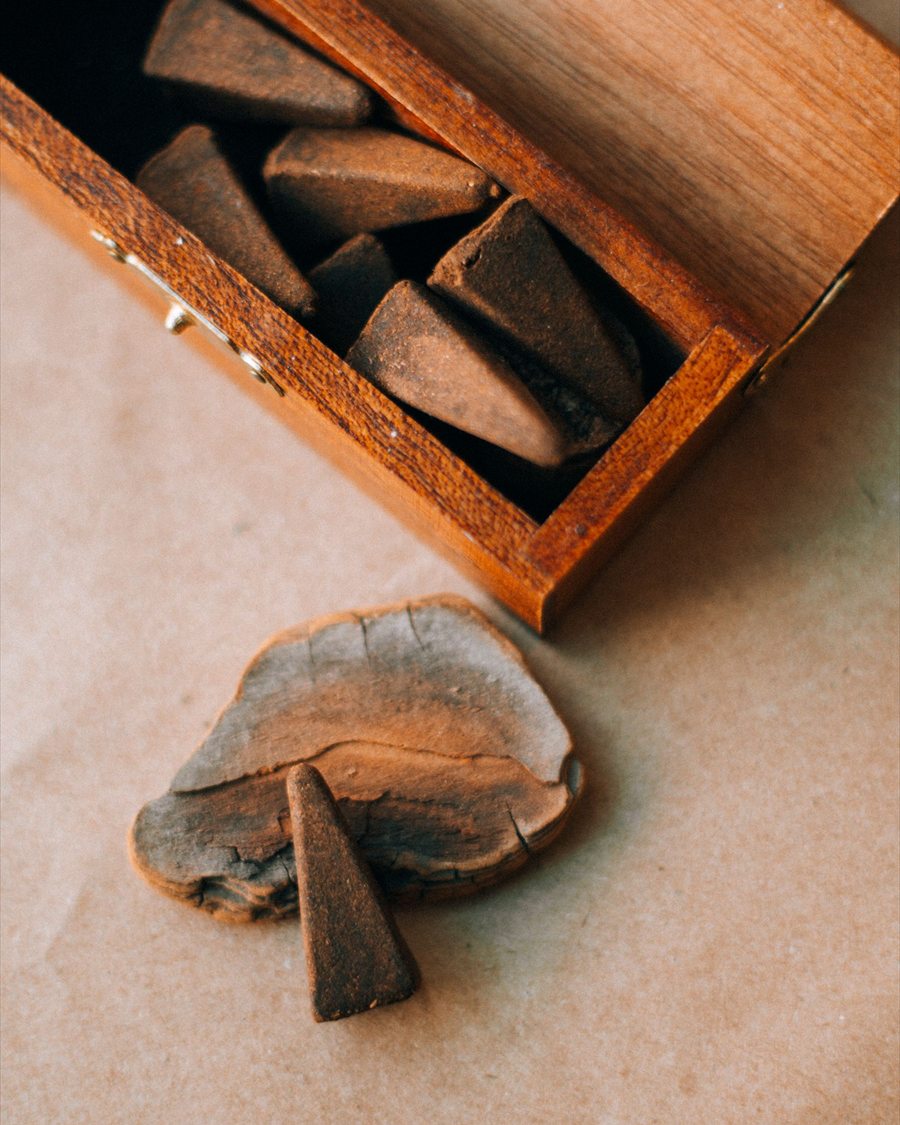Dark incense cones arranged in a divided wooden box